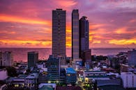 马尼拉摩天大楼的城市景观在五颜六色的日落与海景中令人惊叹