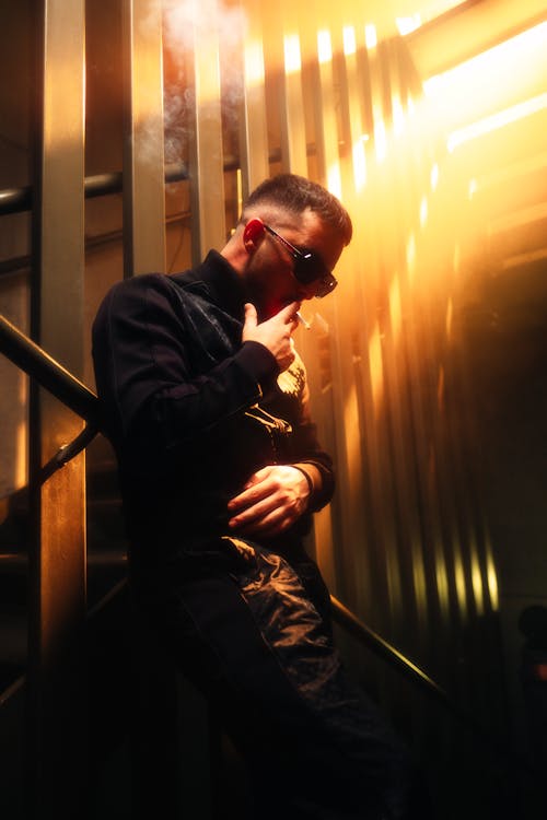 A man smoking a cigarette in a stairwell