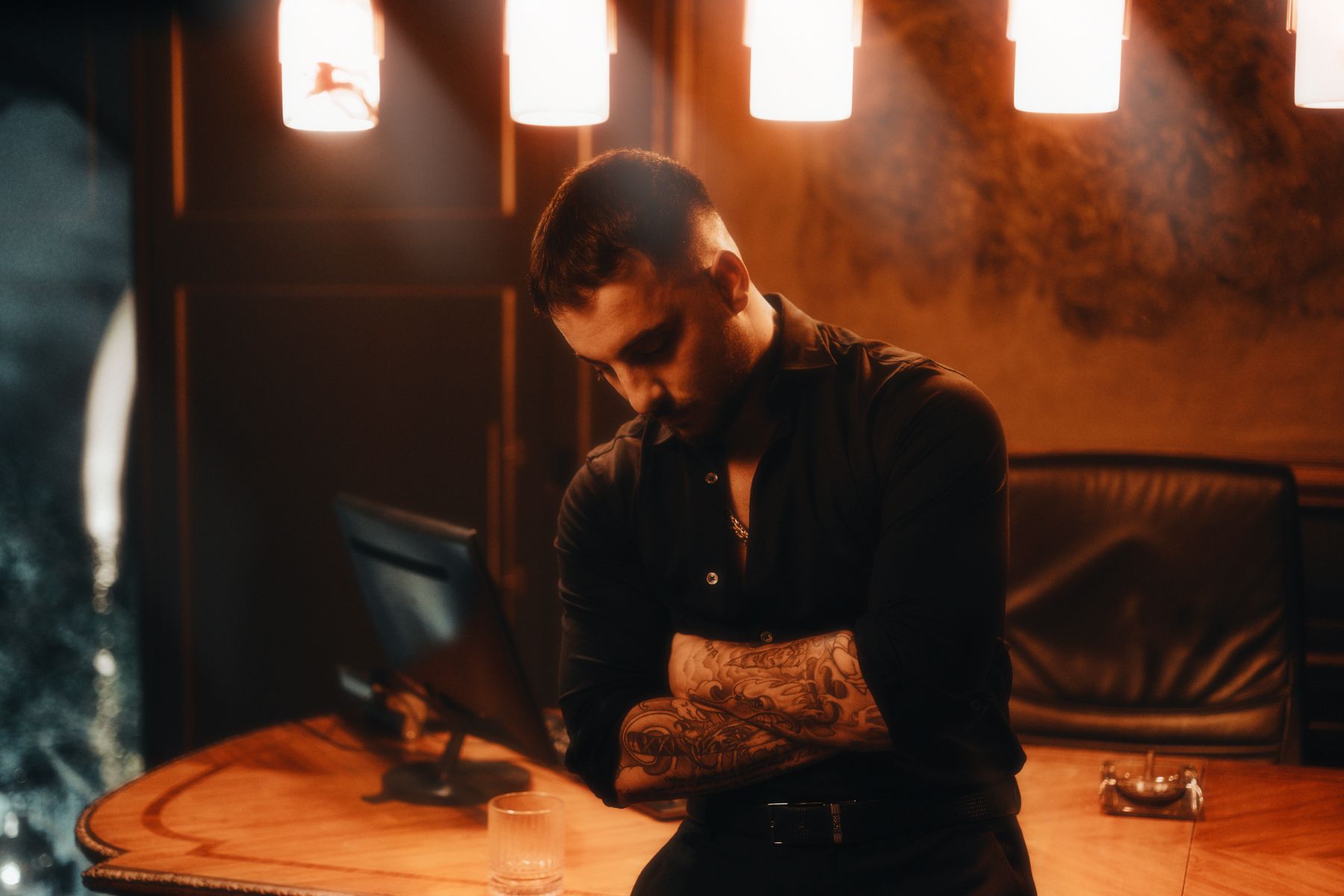 A colleague at a desk in a dim, warm-lit room — photo by Wolrider YURTSEVEN on Pexels