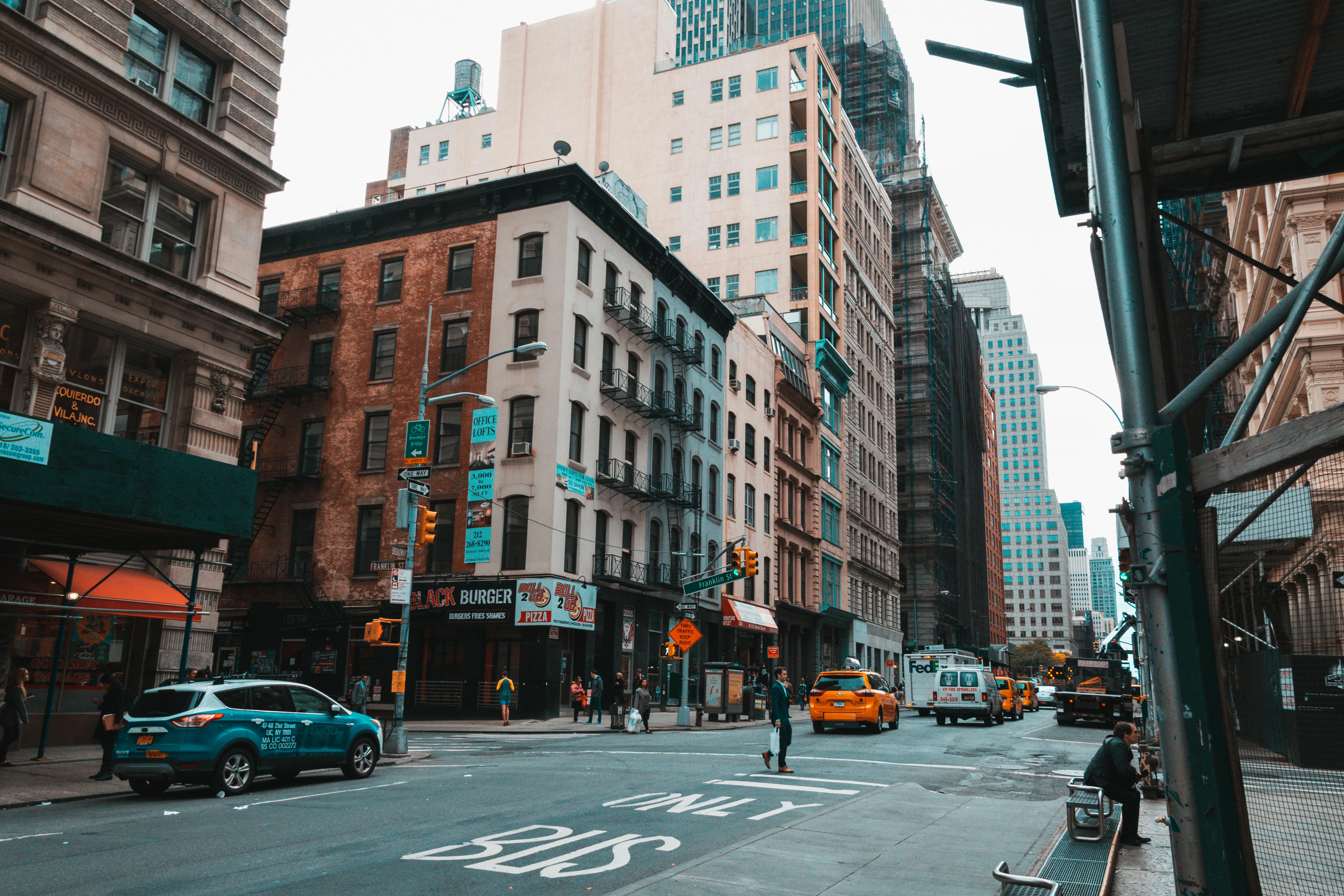 Vehicles On Road Near White And Brown Buildings Free Stock Photo