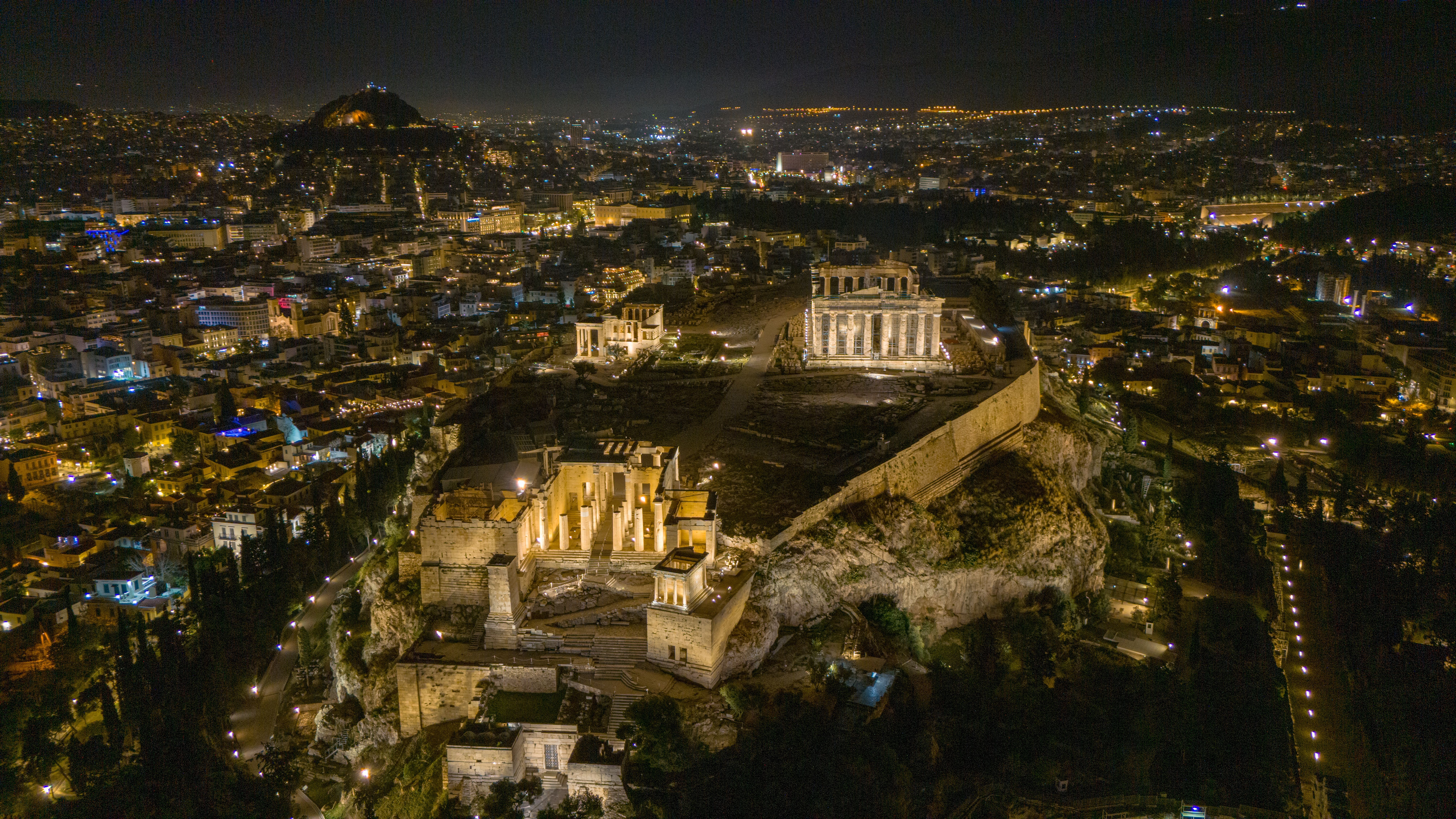 A breathtaking nighttime aerial view of the Acropolis illuminated in Athens, Greece.