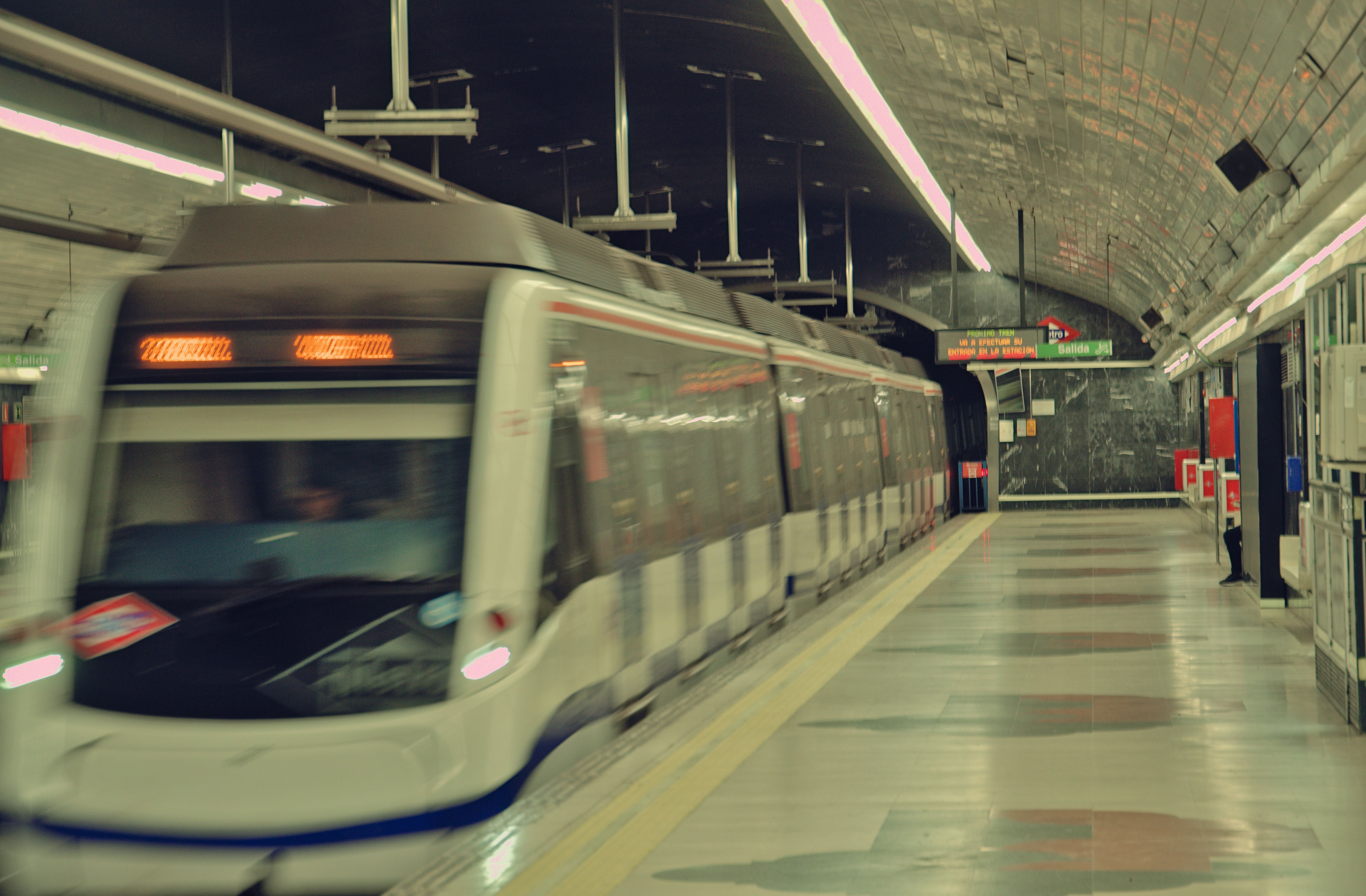 High-speed train departing a dimly lit subway station in Madrid at night, showcasing urban transit. High-speed train departing a dimly lit subway station in Madrid at night, showcasing urban transit.