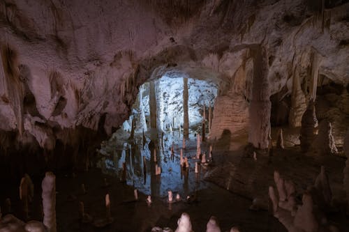 A cave with many pillars and water in it