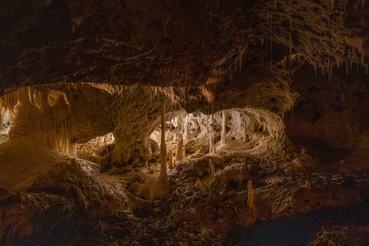 Explore the stunning interior of a cave, featuring intricate stalactites and stalagmites formations.