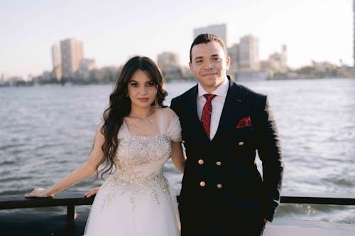 Free A bride and groom standing on a boat in front of the city Stock Photo