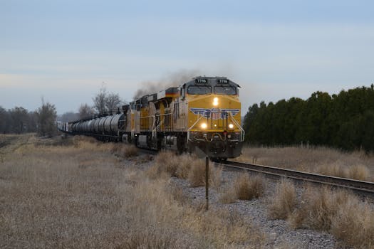 Freight locomotive travels through rural Iowa landscape. Captured outdoors.