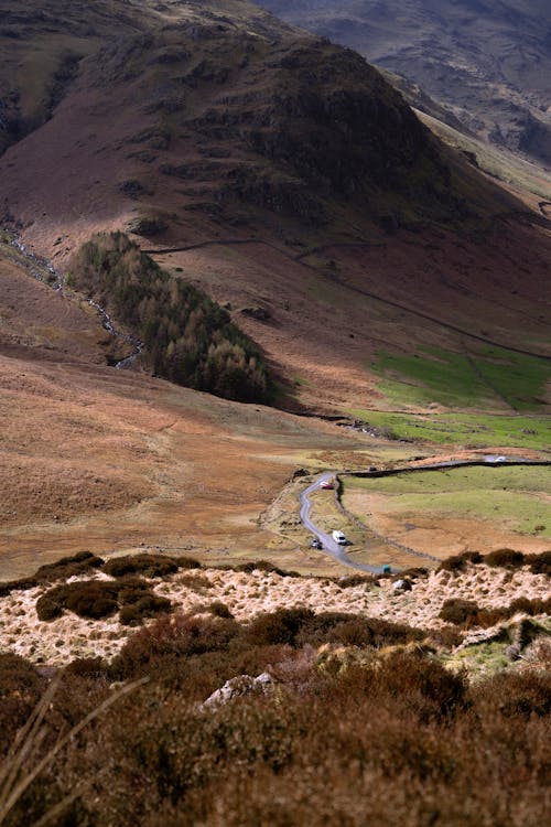 A road winding through the mountains with a valley in the background