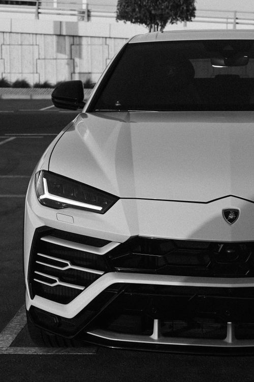 Free Monochrome image of a luxury car parked on city streets, capturing elegance and modern design. Stock Photo