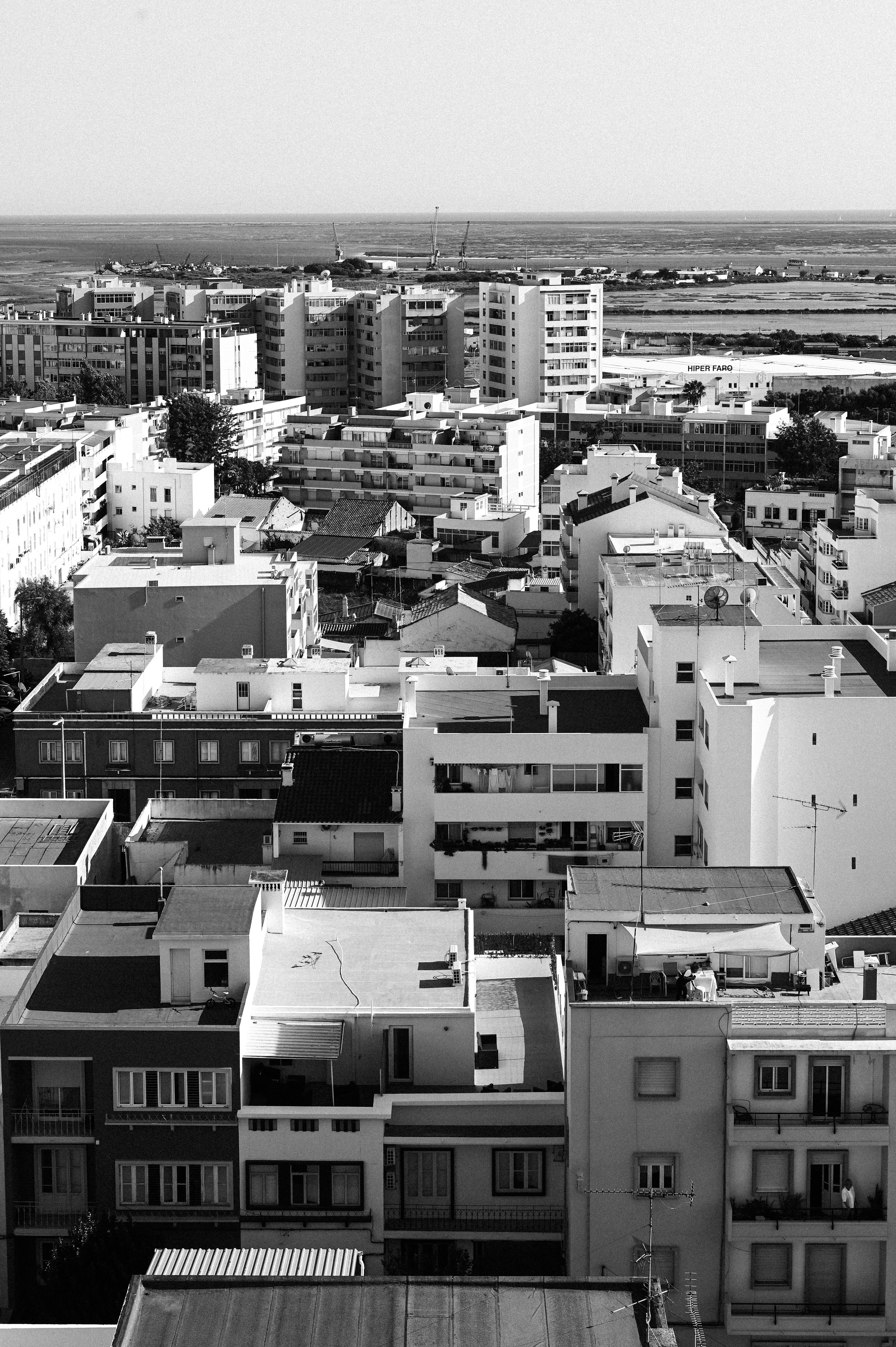 Grayscale aerial view of urban apartment buildings and city skyline.