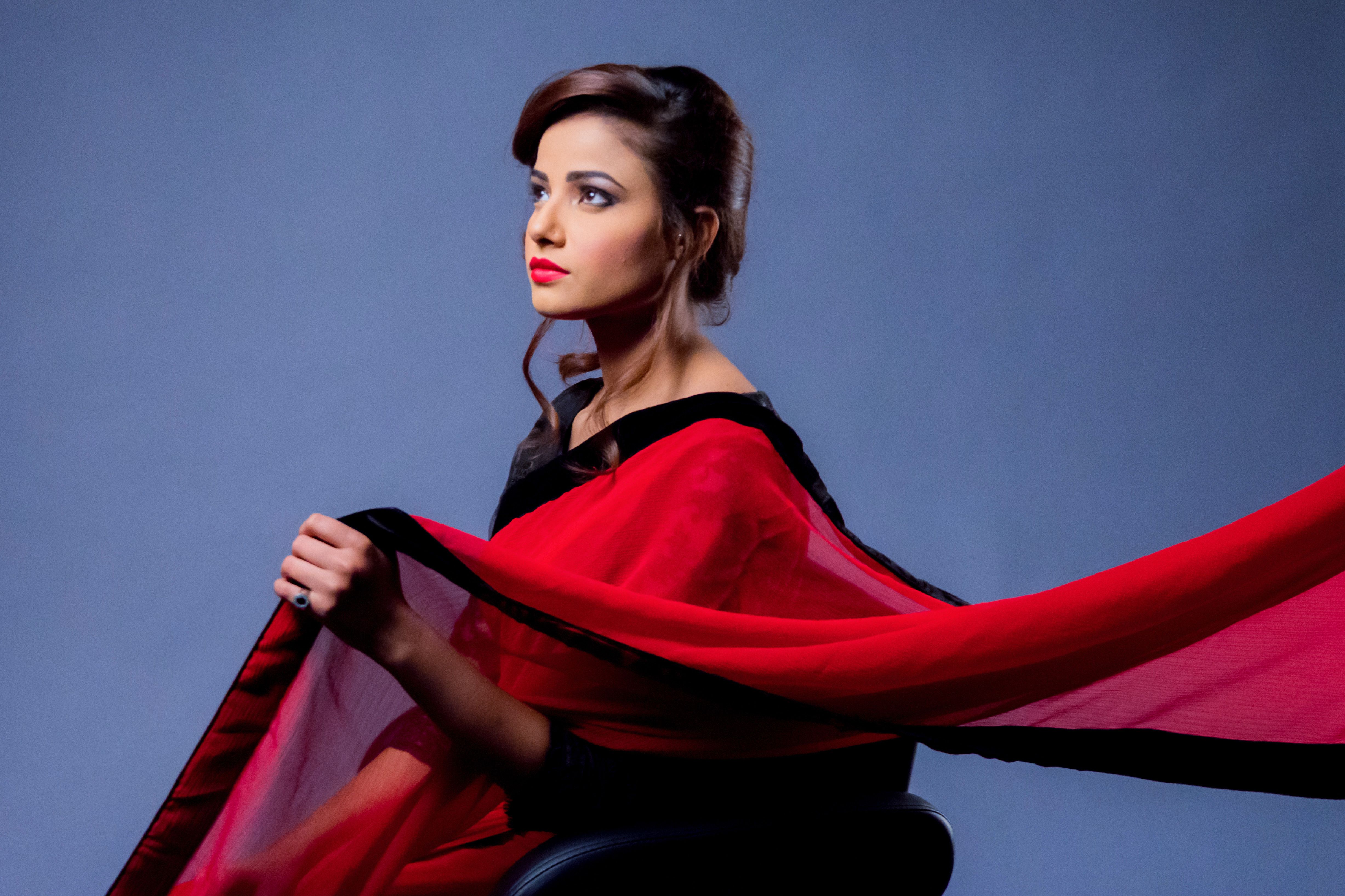 Stunning portrait of a woman in a red saree, embodying elegance and modern fashion.