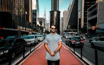 一名男子自信地站在城市熙熙攘攘的街道上，四周高楼林立