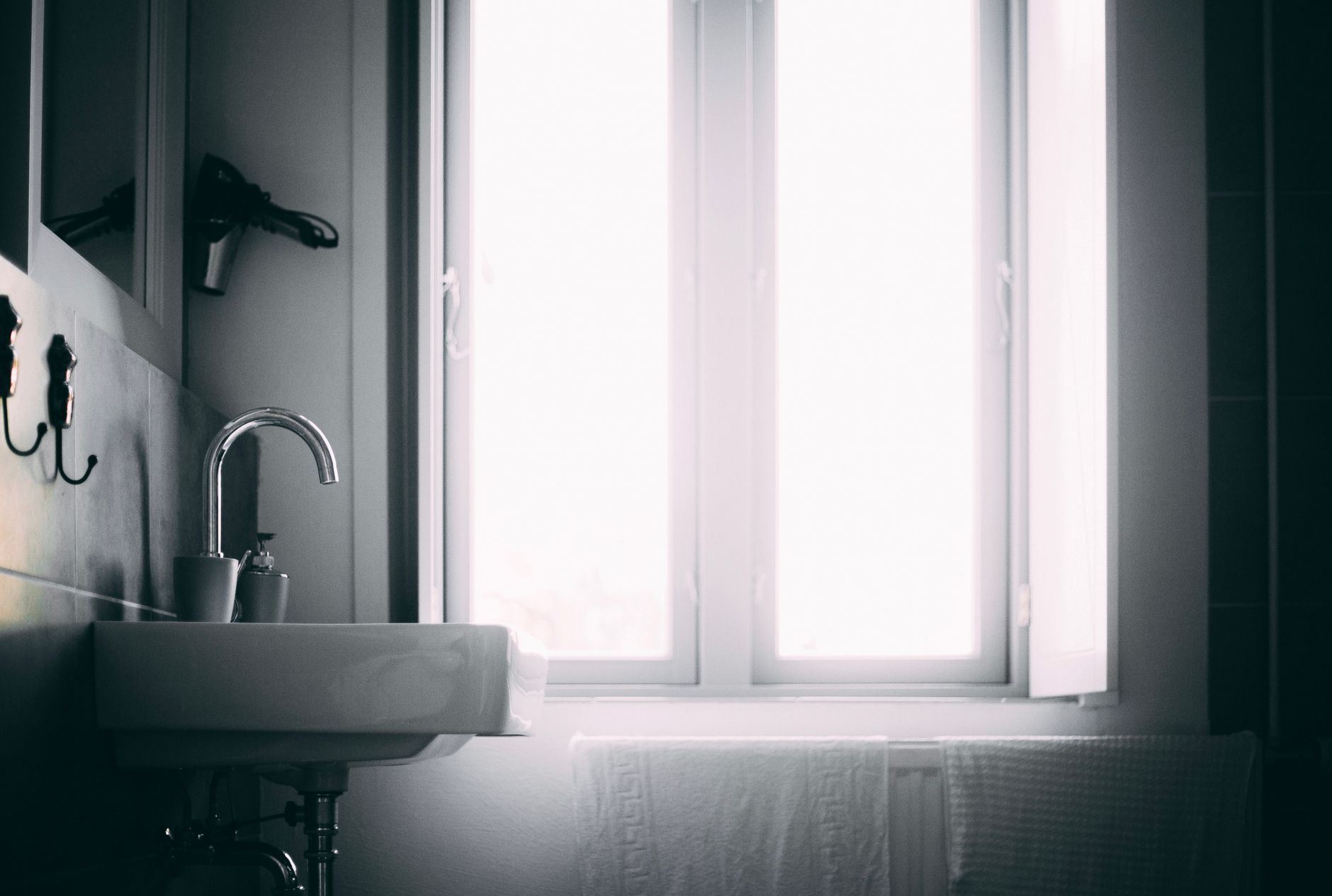 Bright minimalist bathroom featuring a sleek sink and natural light source.