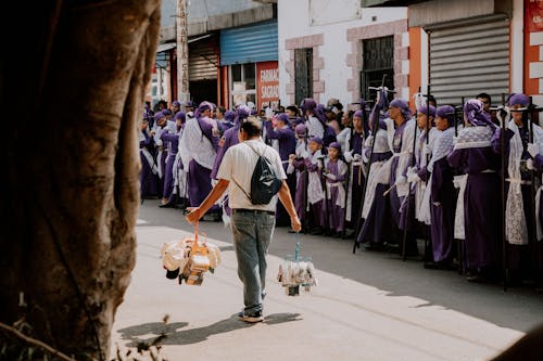 A man in purple robes walking down a street