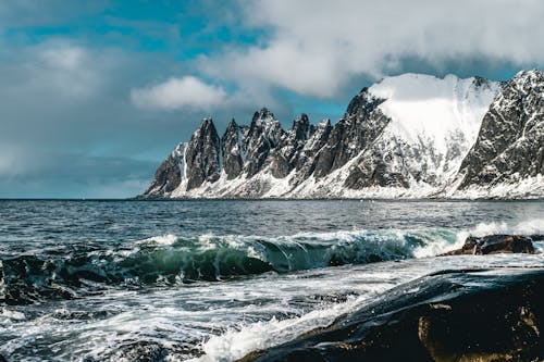 Water Waves Hitting Rocks Near Hill