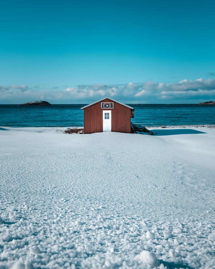 House On Snow Near Body Of Water