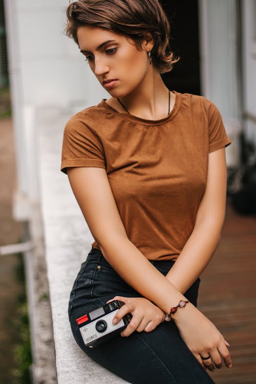 девушка модель в коричневом топе и черных джинсах