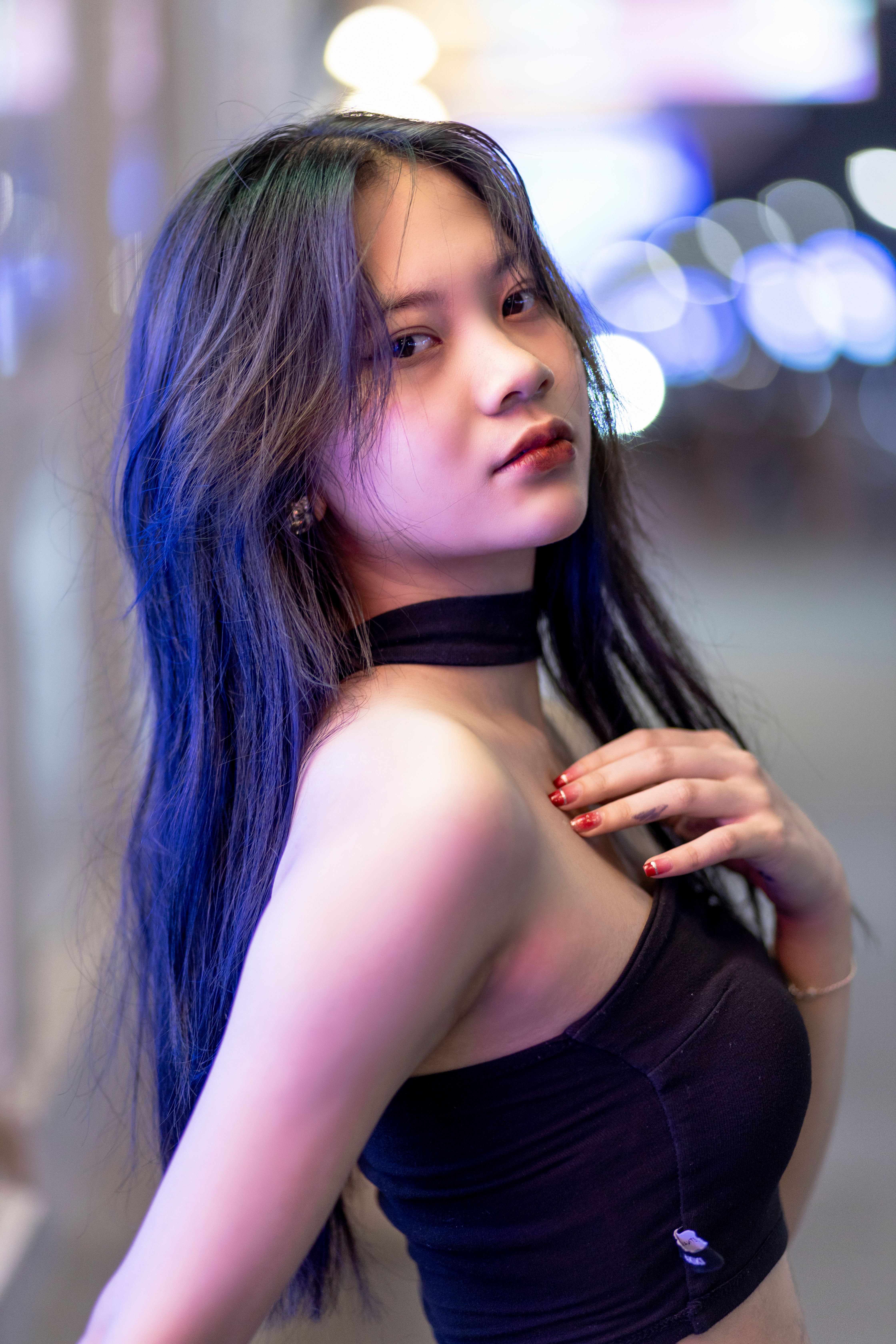 Portrait of a young woman in a black top with a choker, captured in a vibrant and stylish fashion se