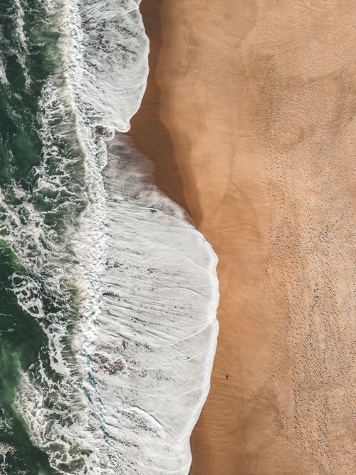 Free Stunning aerial view of waves meeting the sandy shore at Foz do Arelho, Portugal. Stock Photo