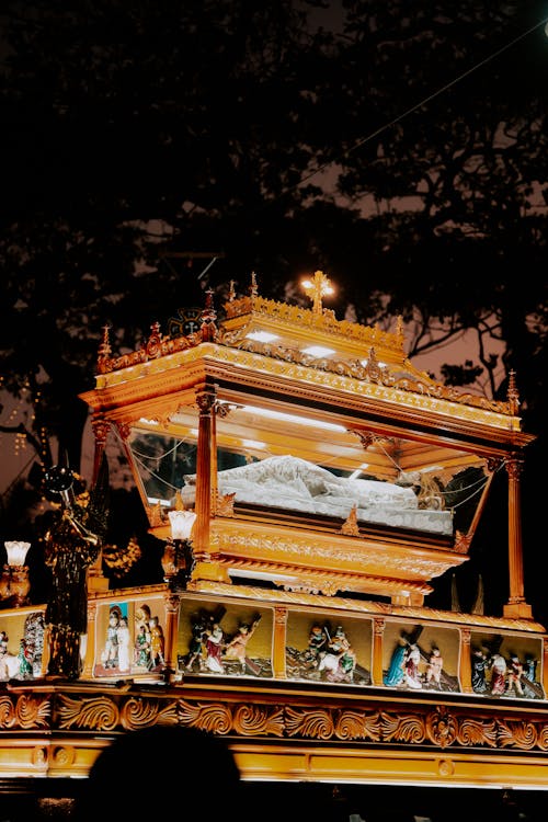 A large wooden coffin is on display at night