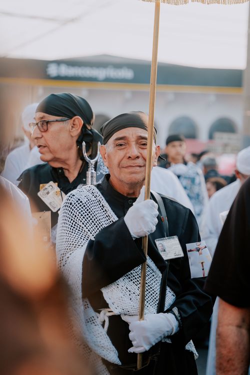 Free Elderly man in traditional attire holding a stick during an outdoor cultural event. Stock Photo