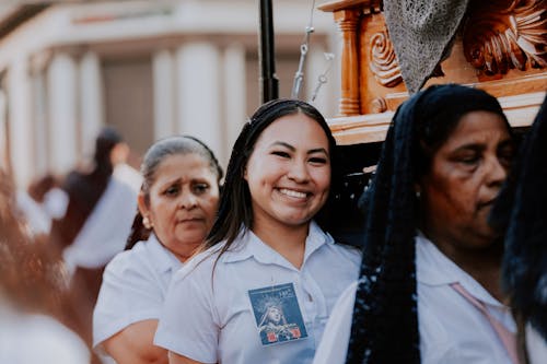 A woman smiles while standing next to a wooden box