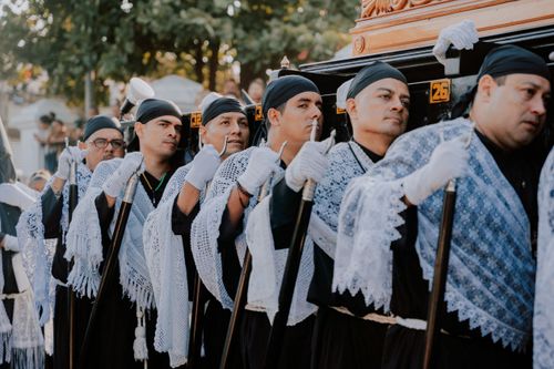 Free Men dressed in traditional clothing participate in a religious ceremony, showcasing cultural heritage. Stock Photo