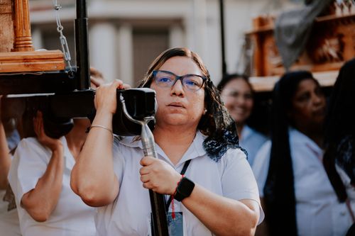 Free A woman carrying a religious statue during an outdoor procession in a ceremonial setting. Stock Photo