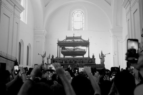 A black and white photo of people taking pictures in a church