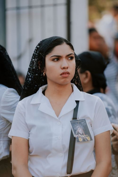 Free Portrait of a young woman wearing a white shirt and black lace veil outdoors. Stock Photo