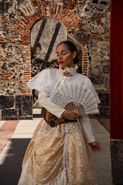 Free A woman in a white dress holding a fan Stock Photo