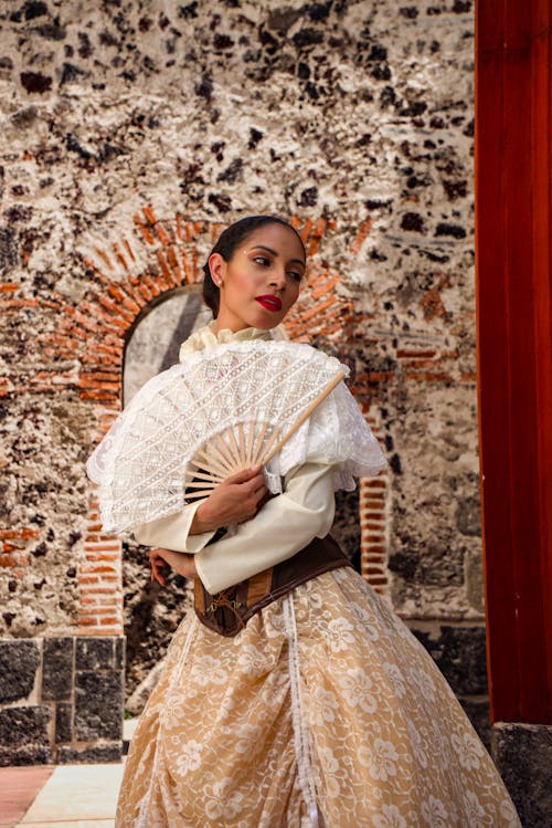 A woman in a dress holding a fan