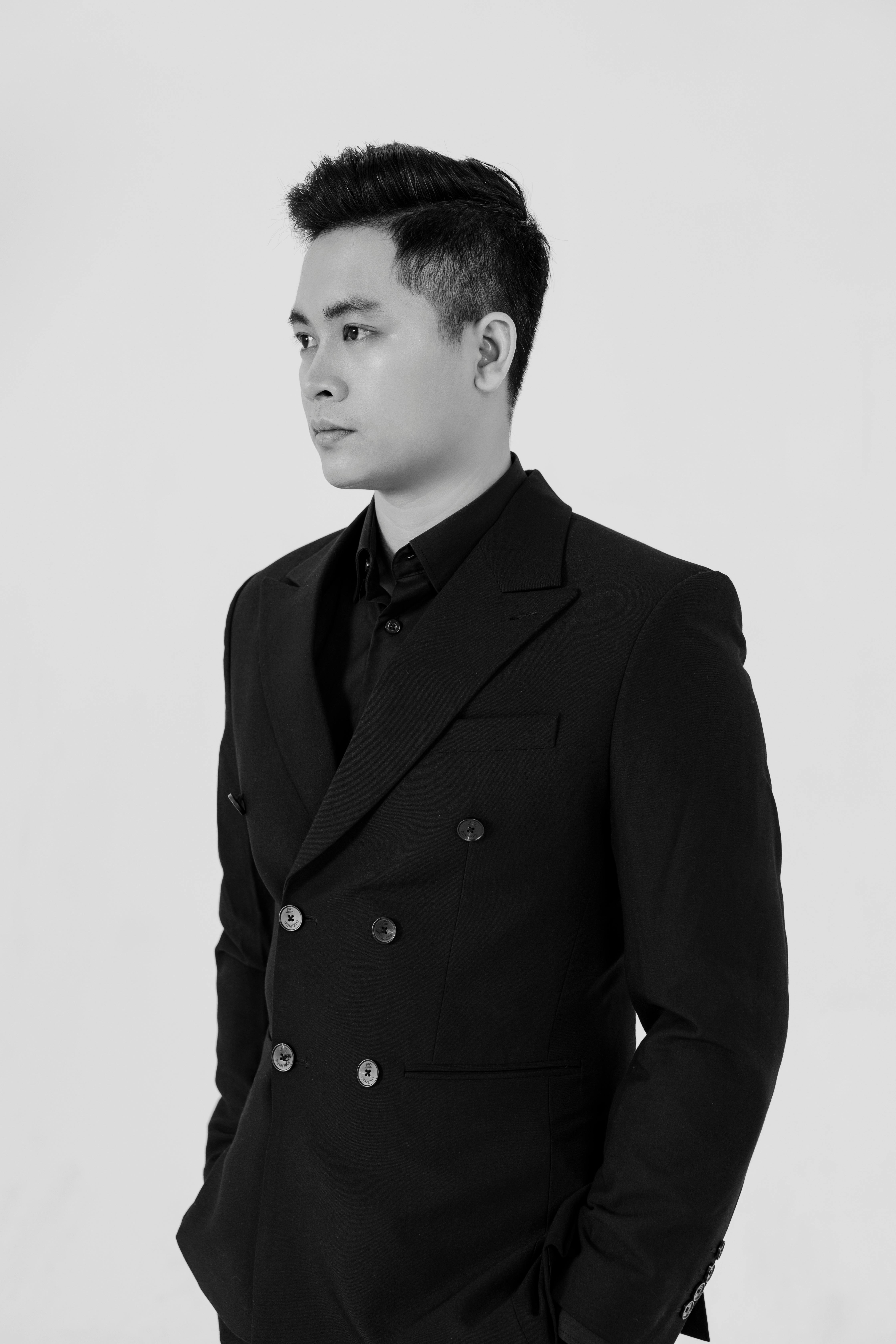 Black and white portrait of an Asian man in a suit exuding elegance and confidence.