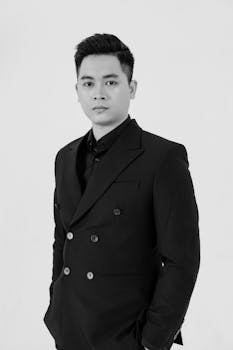 Stylish black and white portrait of an Asian man in a tailored suit.