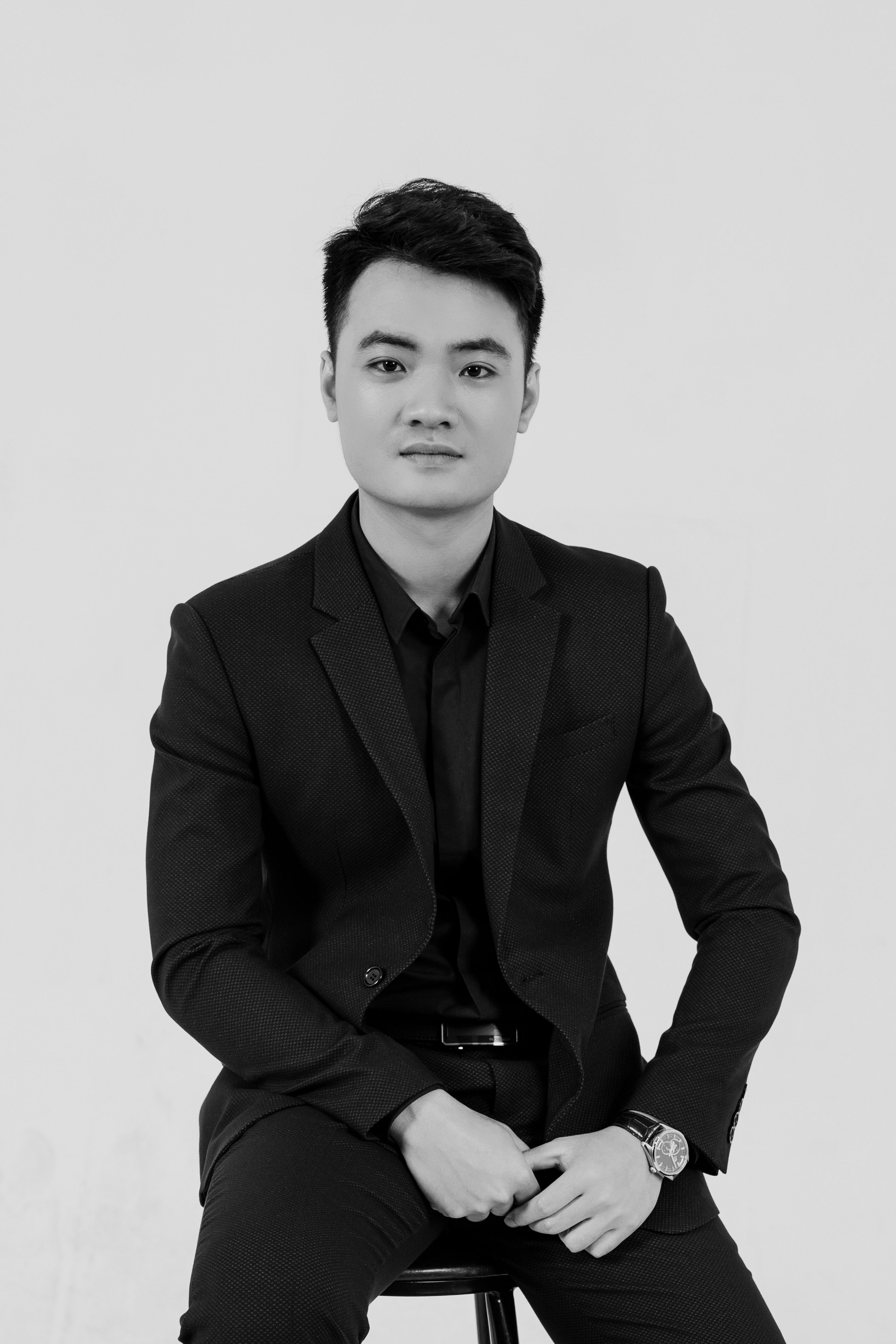 Portrait of a confident businessman in a suit, showcasing professional elegance in a black and white studio setting.