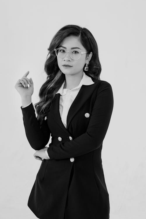 A woman in a suit and tie is posing for a black and white photo