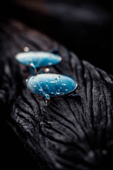 纹理木材表面水滴与蓝色太阳镜的艺术拍摄