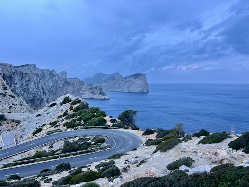 A winding road near the ocean and cliffs