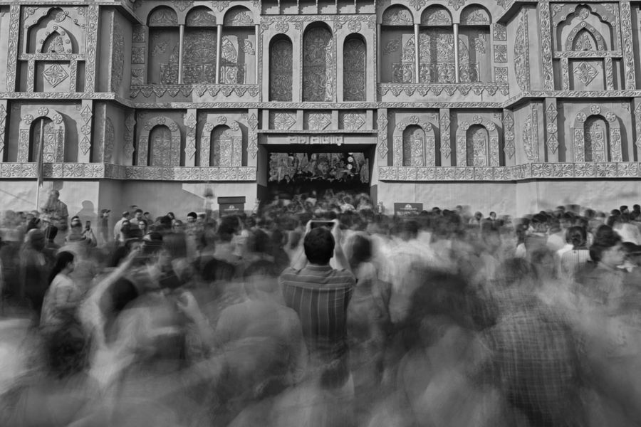 Black and white image of a crowd celebrating Durga Puja at a temple in Kolkata.