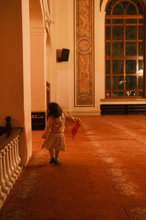 A little girl is walking through a large room