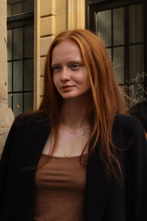 A woman with red hair and a black jacket