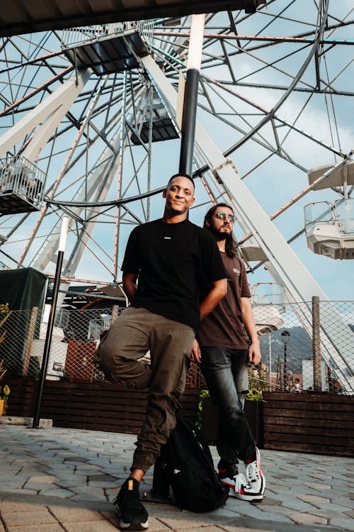 Two people standing in front of a ferris wheel