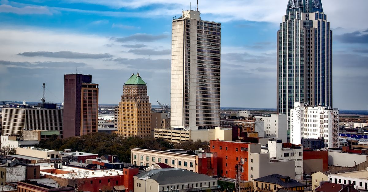 Vibrant urban skyline of Mobile, Alabama featuring iconic skyscrapers under a blue sky.