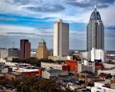 在阿拉巴马州的蓝天下，充满活力的城市天际线中，标志性的摩天大楼缓缓移动