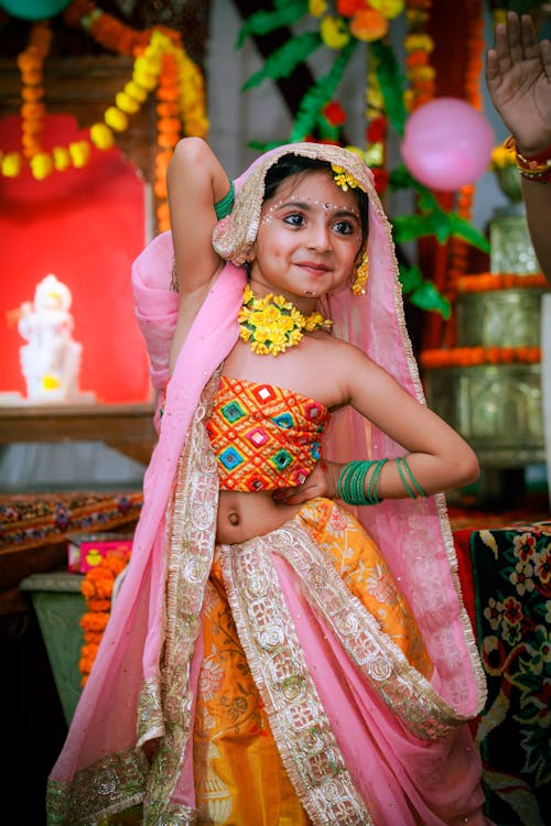 A young girl in a colorful dress dancing