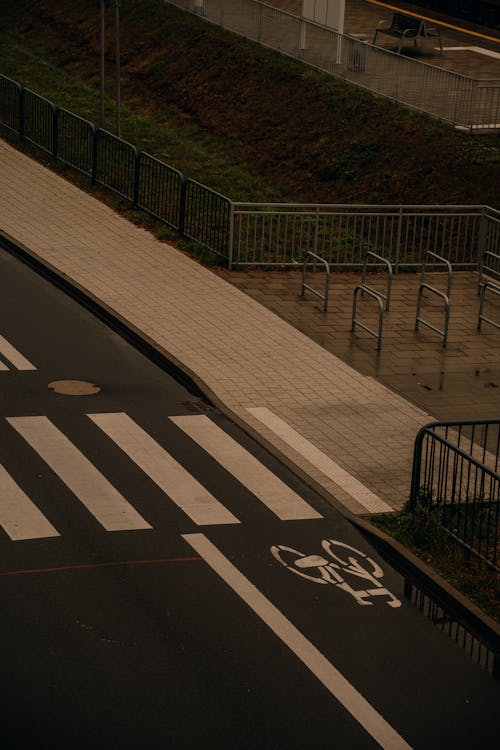 A person walking on a sidewalk with a bike