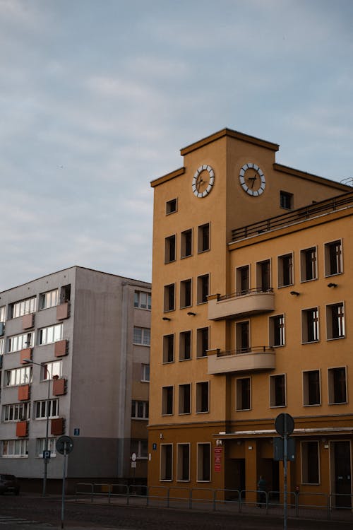 A yellow building with a clock on the side