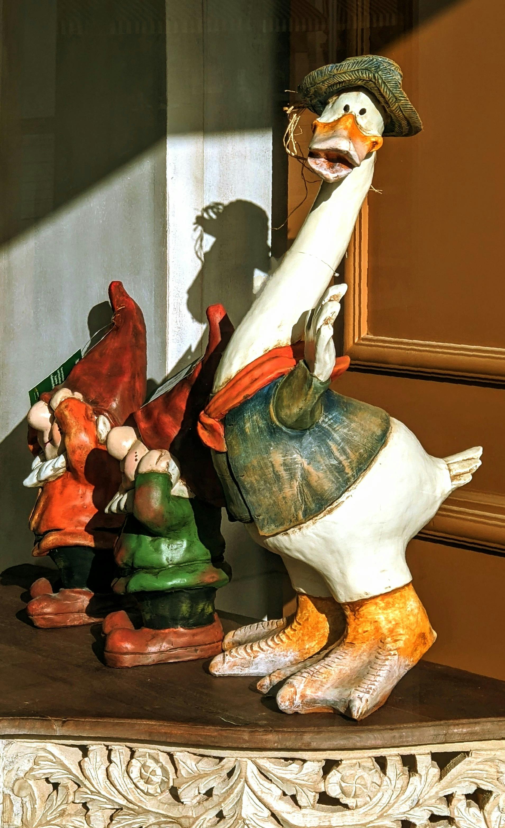 a statue of a duck and two gnomes