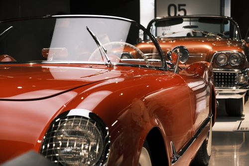 Free A beautifully preserved vintage red cabriolet showcased at a car exhibition indoors. Stock Photo