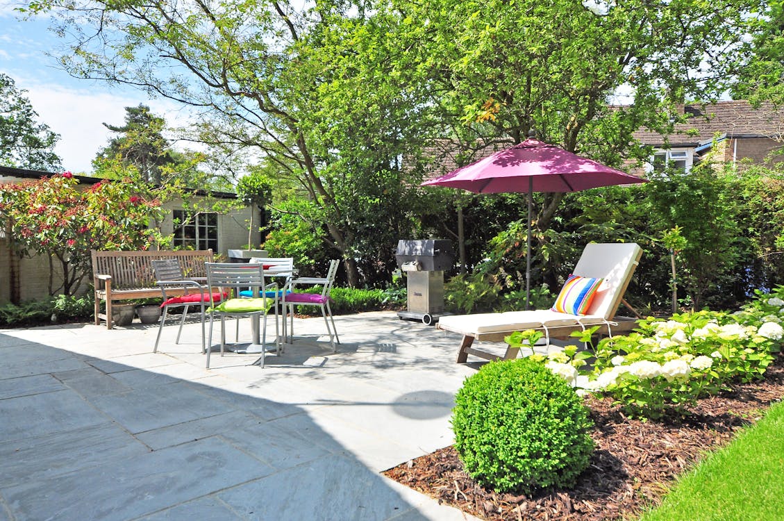 Sunlounger Near Umbrella and Plant