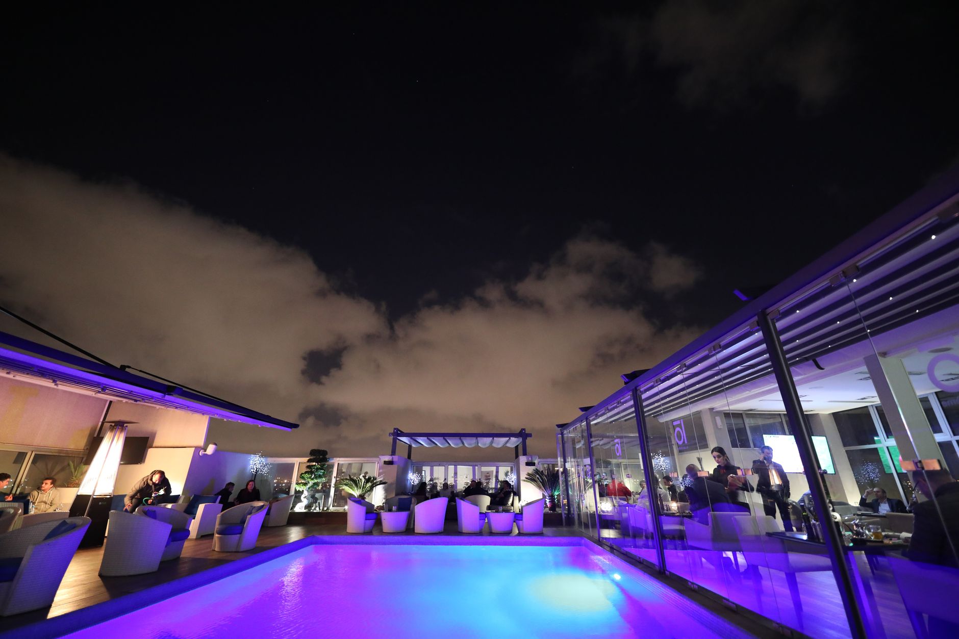 Bangkok skyline seen from a rooftop infinity pool at dusk.